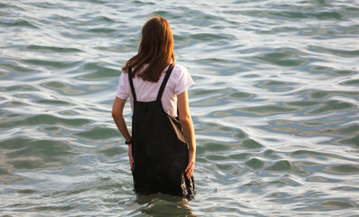 A girl in a dress walks on the water