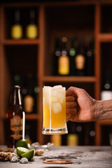Male hand with mug of fresh ginger beer on table in bar