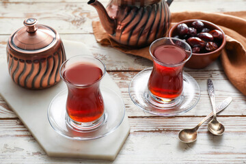 Composition with cups of hot Turkish tea on light wooden background