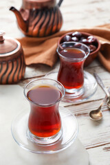 Cups with hot Turkish tea on light wooden background