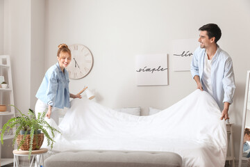 Young couple making their bed