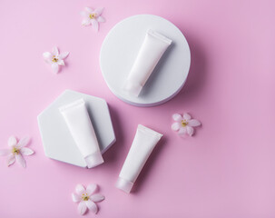 Obraz na płótnie Canvas White tubes of cream on a pink background