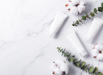 White tubes of cream on a marble background