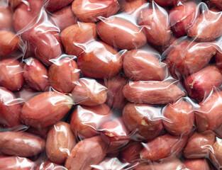 Close up of peanut nuts in a plastic bag as a background. Macro