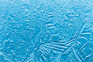 Blue patterns from frost on glass as a background.