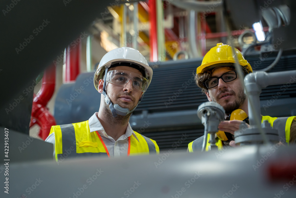 Wall mural two engineers working and checking information in a factory,they work a heavy industry manufacturing