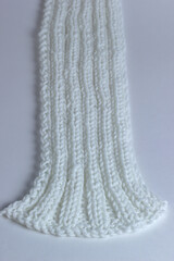 White knitted textured background with a pattern, acrylic and cotton knit fabric, closeup. Copy spase. White background