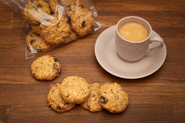 Breakfast with cereal cookies. Oatmeal cookies with cereals and nuts with a cup of coffee on a brown wooden table. Healthy food Snack concept.