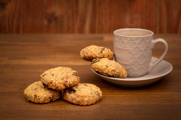oatmeal cookies with cereals and nuts with a cup of coffee on a brown wooden background. Healthy food Snack concept. Copy space.