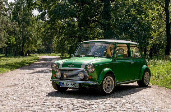 HUNGARY - May, 2012: Green classic Austin Mini Cooper retro vehicle parked on the road against the background of a forest at the International Mini Meeting 2012. Automotive photography. Retro car.
