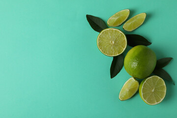 Fresh limes and leaves on mint background