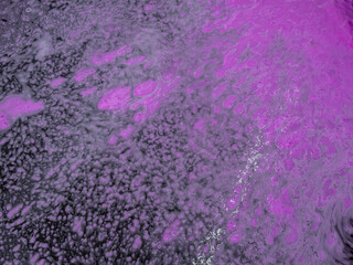 Colorful magenta bath foam with bubbles on the ground. Effect of space and galaxy. Beauty and luxury backdrop. Abstract art. Beautiful pink soap background with waves and foam. Washing suds texture