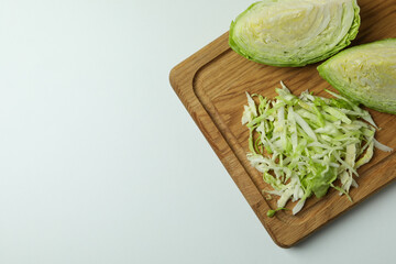 Board with fresh green cabbage on white background