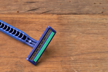 Man's razor over wooden background.