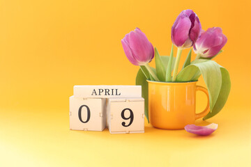 Calendar for April 9: cubes with the numbers 0 and 9, the name of the month April in English, a...