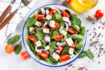 Green vegan salad from green leaves mix and vegetables. Top view on gray stone table.
