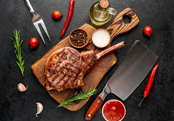 Grilled tomahawk beef steak with spices on stone background