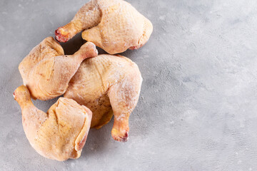 Frozen chicken legs on a light background. Raw chicken meat. Top view, copy space