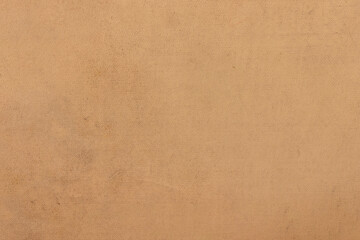 The surface of old worn brown cardboard, covered with creases and stains. Uniform light abstract texture.