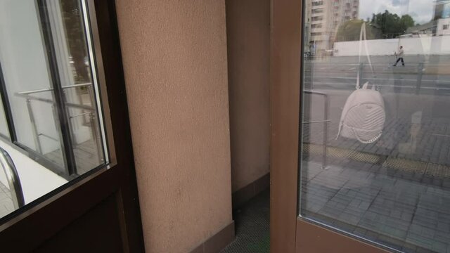 Blonde lady with backpack opens door coming into cinema