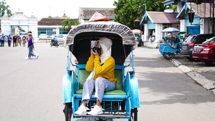 Asian women travel in rickshaws wearing jilbab and analog camera
