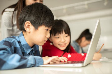 ICT in Education - Elementary School Students and Teacher Looking at PC