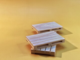 wooden pallets lie on a yellow background © Józef