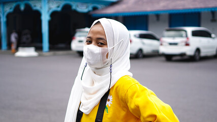 an Asian woman traveler in keraton solo wearing jilbab and analog camera