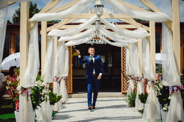 Stylish groom in tuxedo at wedding ceremony. Portrait of happy groom.