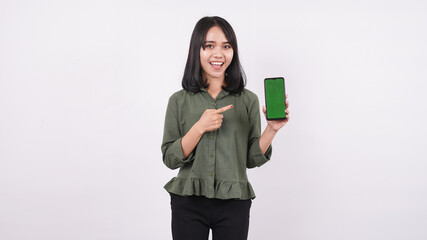 happy young woman pointing at green telephone on a white isolated background
