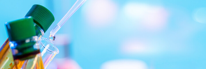 Chemical test tube and pipette with a drop of colorless liquid and two test tubes with yellow...