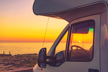 Camper car on sea at sunset