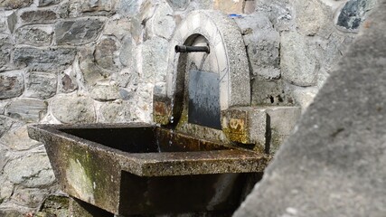 Clear and cold water flowing from metal pipe, fountain, waterplace, side view