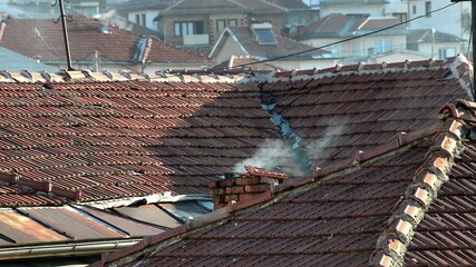Smoke coming from chimney on house roof top