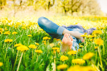 Young girl resting in a dandelion field