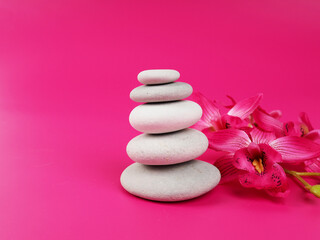Obraz na płótnie Canvas A stack of white zen stones on a pink background, minimalism