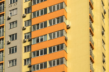 The facade of a multi-storey building with windows and balconies as an element of the architecture of a modern city