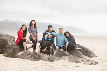 Interracial family of six on beach with special needs child