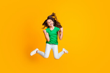 Fototapeta na wymiar Full size photo of happy excited crazy good mood screaming girl jumping in triumph isolated on yellow color background