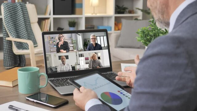 business people working remote from home discuss corporate project video call conference,man at his desk sharing company data to group of colleagues coworkers online meeting on laptop screen