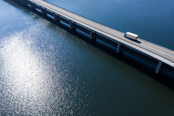 a truck driving on a bridge in the water