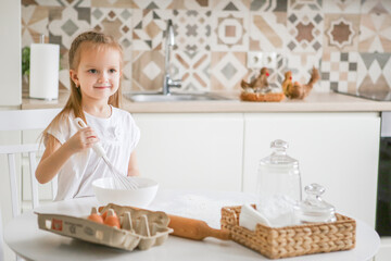 Obraz na płótnie Canvas happy caucasian girl funny child prepares dough, bake cookies, donut, pie in the kitchen.