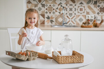 happy caucasian girl funny child prepares dough, bake cookies, donut, pie in the kitchen.