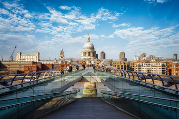 Perspective view to the skyline of London, United Kingdom, with St. Pauls Cathedral and blurred people walking during a sunny spring day