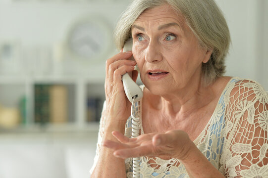 Portrait Of Upset Senior Woman Calling Doctor