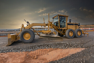 Excavator machine leveling the ground at a road construction site
