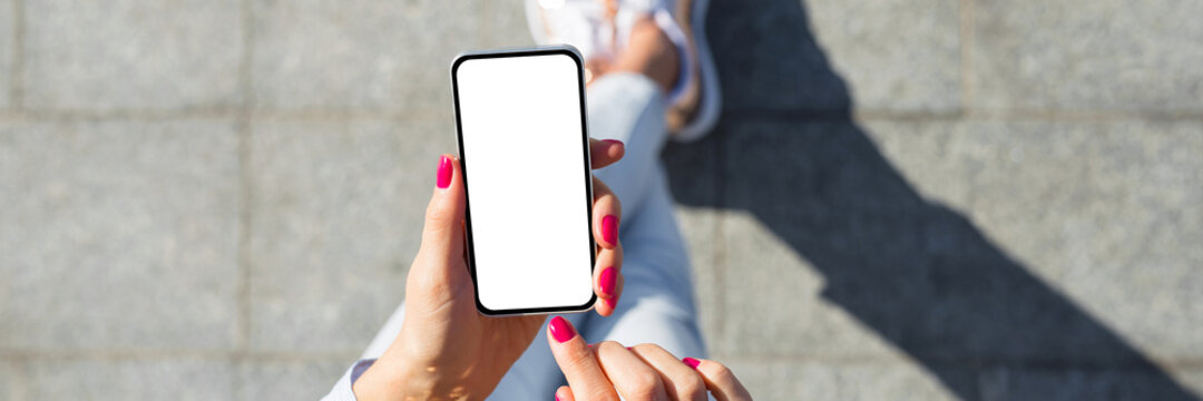 Panoramic photo of woman using mobile phone with blank white screen
