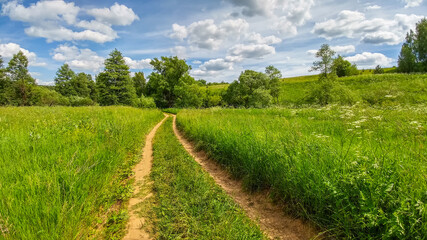 Beautiful landscape of a road that stretching to the horizon under beautiful clouds in the blue sky in the springtime