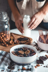 Ideas for an autumn winter breakfast. Spicy yoghurt with granola, dried berries, nuts, almonds, spices (cinnamon, anise), in cup, plate.