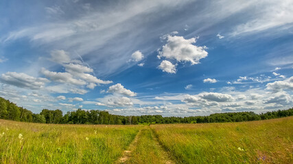 Beautiful landscape of a road that stretching to the horizon under beautiful clouds in the blue sky in the springtime